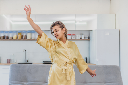 Beautiful girl in bathrobe relaxing at home.Young Woman In Her Morning Routine, After A Shower.Beautiful girl in bathrobe relaxing at homeの写真素材