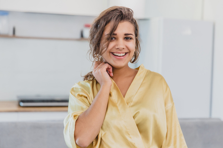 Beautiful girl in bathrobe relaxing at home.Young Woman In Her Morning Routine, After A Shower.Beautiful girl in bathrobe relaxing at homeの写真素材