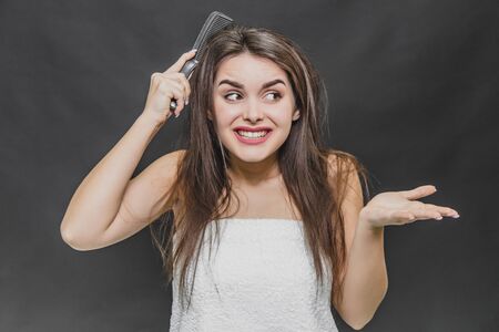 Hair Care. Closeup Of Beautiful Girl After Bath Hairbrushing Healthy Straight Brown Hair. Young Woman Brushing Her Long Wet Hair With Wooden Comb. Health And Beauty Concept.の写真素材