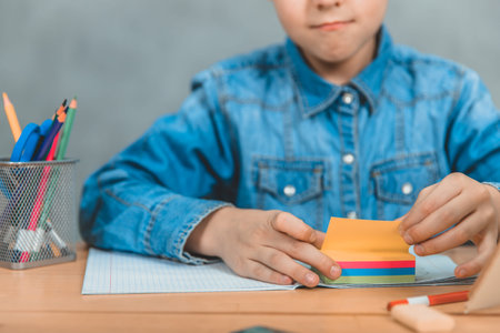Learning process. Gray background. Crop, blurred, focus on the colorful stickers.