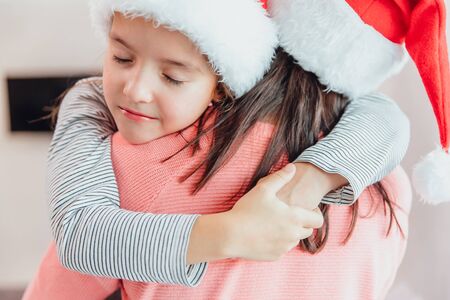 Cropped shot of loving mother and daughter hugging near christmas tree, looking amazing.の写真素材