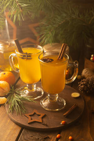 Two glass mugs with sea buckthorn tea. Hot drink with cinnamon sticks and stars of star aniseの写真素材