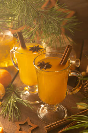 Two glass mugs with sea buckthorn tea. Hot drink with cinnamon sticks and stars of star aniseの写真素材
