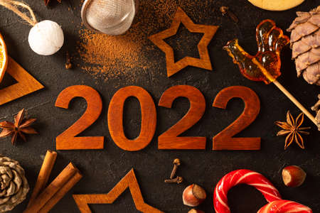 There are stars carved out of wood, spices, scattered cocoa and a mug with marshmallows aroundの写真素材
