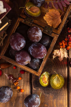 Plums in a box. Two halves of a plum cut in half lie side by side.の写真素材