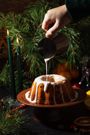 a round cupcake on a dark background is poured from a saucepan with icing on top