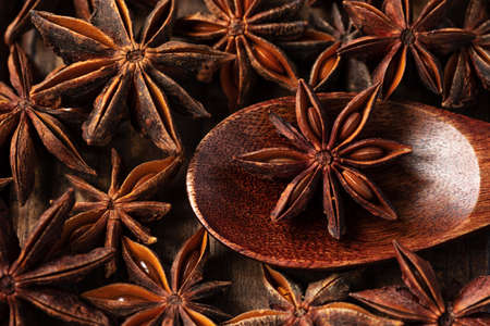 macrophotography of star anise on a wooden background. tubs lies in a wooden spoonの写真素材