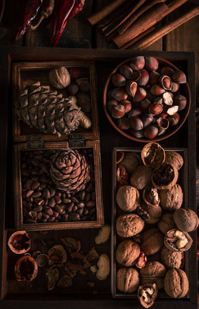 a wooden tray full of different types of nuts. whole and chopped nuts in different boxes nextの写真素材