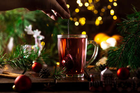 red tea in a glass. tea drips from a tea strainer on top.の写真素材