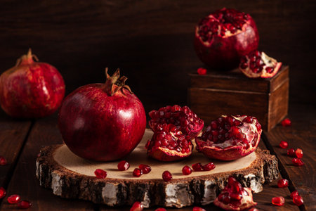 ripe pomegranates on a wooden background. The cut fruits of the pomegranate tree.の写真素材