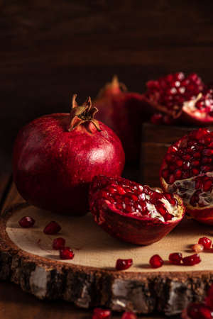 ripe pomegranates on a wooden background. The cut fruits of the pomegranate tree.の写真素材