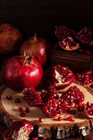 ripe pomegranates on a wooden background. The cut fruits of the pomegranate tree.の写真素材