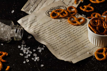 the recipe for making pretzels is written on a piece of paper, next to it lies salt and pretzels.の写真素材