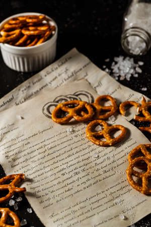 the recipe for making pretzels is written on a piece of paper, next to it lies salt and pretzels.の写真素材