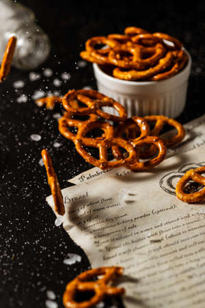the recipe for making pretzels is written on a piece of paper, next to it lies salt and pretzels.の写真素材