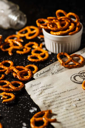 the recipe for making pretzels is written on a piece of paper, next to it lies salt and pretzels.の写真素材