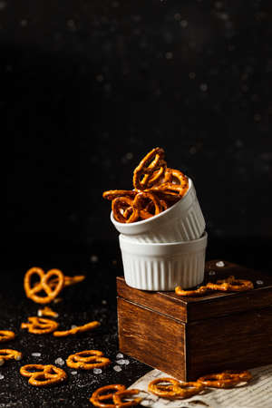 pretzels with salt fall from a white cup.の写真素材