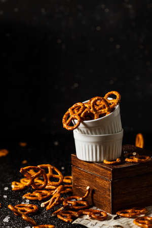 pretzels with salt fall from a white cup.の写真素材
