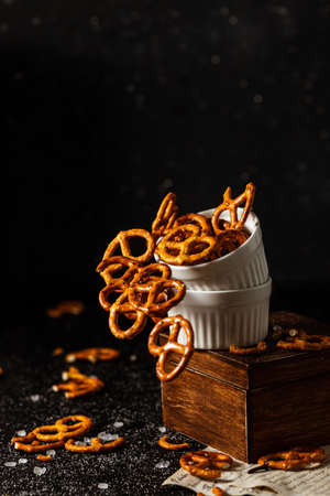pretzels with salt fall from a white cup.の写真素材