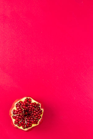 An open pomegranate on a pink background. Space for text.の写真素材