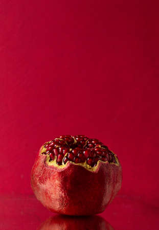 An open pomegranate on a pink background. Space for text.の写真素材