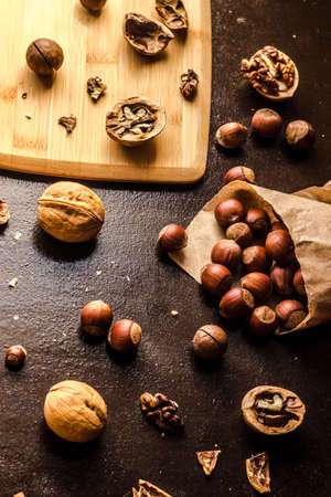 Walnuts and hazelnuts are on the table. Whole and broken nutshells lie on a backgroundの写真素材