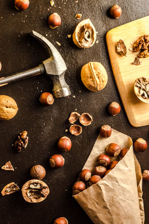 Walnuts and hazelnuts are on the table. Whole and broken nutshells lie on a backgroundの写真素材