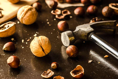 Walnuts and hazelnuts are on the table. Whole and broken nutshells lie on a backgroundの写真素材