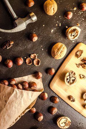 Walnuts and hazelnuts are on the table. Whole and broken nutshells lie on a backgroundの写真素材