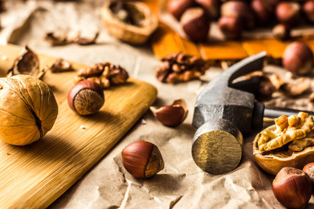 Walnuts and hazelnuts are on the table. Whole and broken nutshells lie on a background