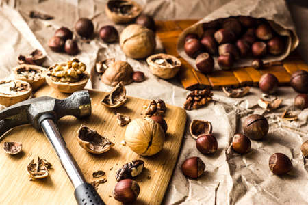 Walnuts and hazelnuts are on the table. Whole and broken nutshells lie on a backgroundの写真素材