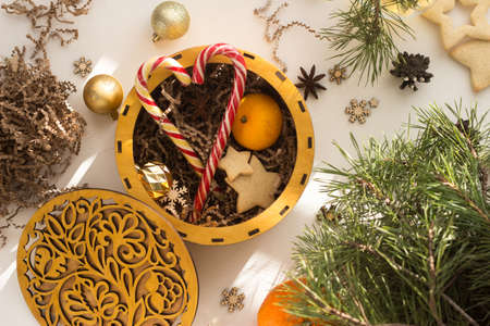 a round box with a patterned lid full of cookies and Christmas sticks.の写真素材