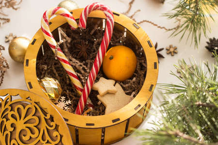a round box with a patterned lid full of cookies and Christmas sticks.の写真素材