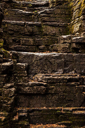 a stone wall. stands of brown stones strewn with autumn leavesの写真素材