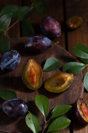 Plum cut in half on a wooden boardの写真素材