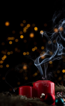 Two freshly dried red candles on the New Year's table. white smoke comes from the wicksの写真素材