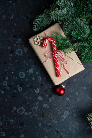 On the table is a gift surrounded by Christmas tree branches, wooden toys and spicesの写真素材