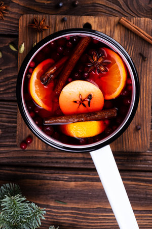 A white ladle with boiled mulled wine stands on a wooden tableの写真素材