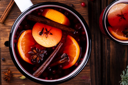 A white ladle with boiled mulled wine stands on a wooden tableの写真素材