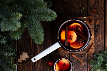 A white ladle with boiled mulled wine stands on a wooden tableの写真素材