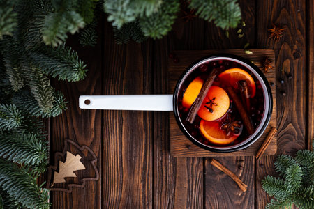 A white ladle with boiled mulled wine stands on a wooden tableの写真素材