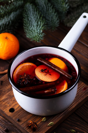 A white ladle with boiled mulled wine stands on a wooden tableの写真素材