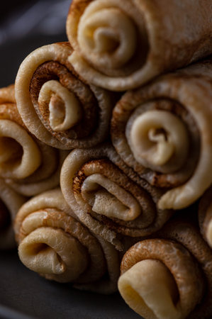 pancakes rolled up into tubes lie on a slide