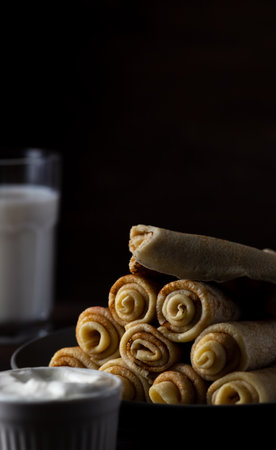 pancakes rolled up into tubes lie on a slideの写真素材