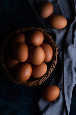 Chicken eggs in a wicker basket and on a towelの写真素材