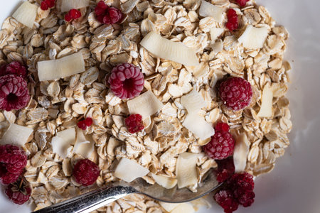 Oatmeal in a bowl with berries and coconut chipsの写真素材