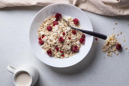 Oatmeal in a bowl with berries and coconut chipsの写真素材