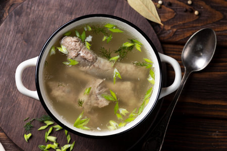 Chicken soup with dill and parsley in a bowl on wooden backgroundの写真素材