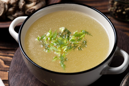 Mushroom soup with dill in a bowl on wooden backgroundの写真素材