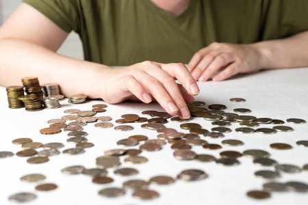 Counting coins on a wooden tableの写真素材